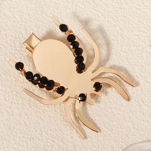 Vue détaillée de la pince à cheveux araignée dorée avec perles de cristal noir et fil