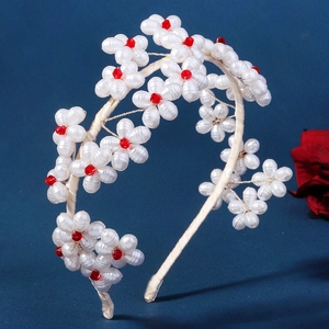 Elegant white faux pearl floral headband with red bead accents for bridal hair styling