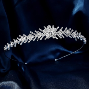 Dettaglio ravvicinato di una corona da sposa in argento con strass su seta blu scuro