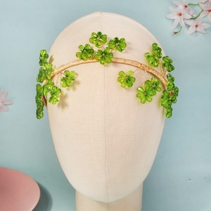 Détail du serre-tête floral en cristal vert avec fil doré pour les mariages
