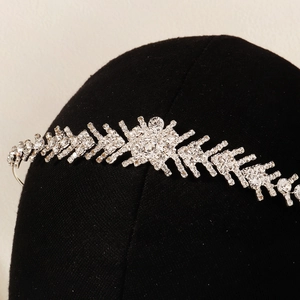 Macro di una tiara da sposa in argento con strass scintillanti su un busto nero