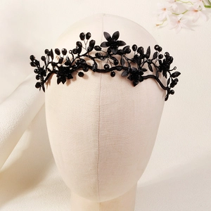 Detailed close-up of handmade black beaded floral crown with crystal accents on a model head