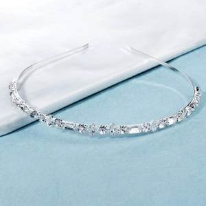 Close-up of thin silver headband with sparkling geometric crystals on a blue background
