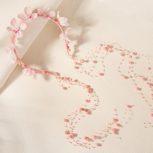 Detailansicht des rosa Chiffon-Blumen-Haarbands mit eleganten langen Perlenquasten
