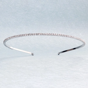 Detailed view of slender silver headband with sparkling zircons on blue background