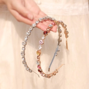 Detailed view of two sparkling crystal zircon headbands with silver and multi-colored stones