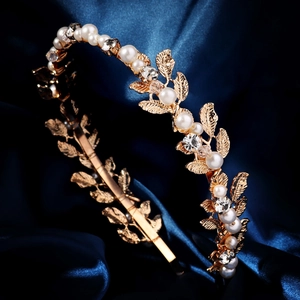 Vintage gold hairband with pearls and rhinestones on blue silk background