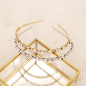 Macro detail of gold and silver hairbands with rectangle rhinestones on a metal stand