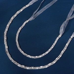 Detailed macro view of sparkling rhinestone bridal belt and headband set with silk ribbons