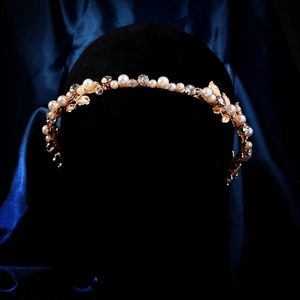 Detailed close-up of a vintage gold headband with intricate pearls and crystals