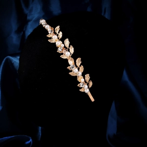 Detail of vintage gold leaf headband with white pearls and sparkling rhinestones