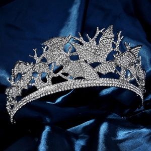 Détail macro d'une couronne gothique de chauve-souris en argent avec strass sur soie bleue