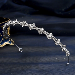 Dettaglio di un cerchietto in argento con strass e design a stella su seta blu scuro