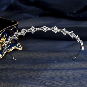 Dettaglio del cerchietto in argento con cristalli geometrici scintillanti su velluto blu