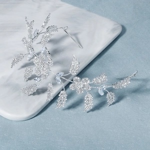 Detailed macro view of handmade silver bridal headpiece with crystal flowers and leaves