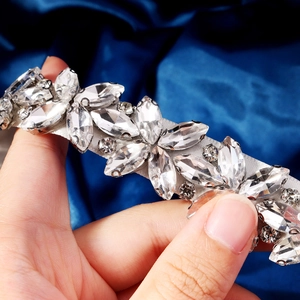 Dettaglio di cintura da sposa in strass con cristalli marquise su raso blu