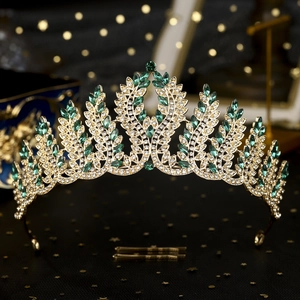 Detail shot of vintage bridal crown with green marquise stones and gold leaf patterns