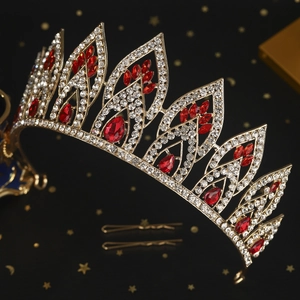 Detailansicht einer goldenen Brautkrone mit roten Edelsteinen und weißen Strasssteinen