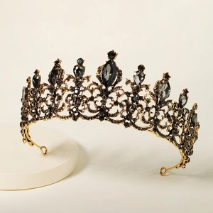 Close-up of vintage gold alloy tiara with intricate hollow design and black crystals