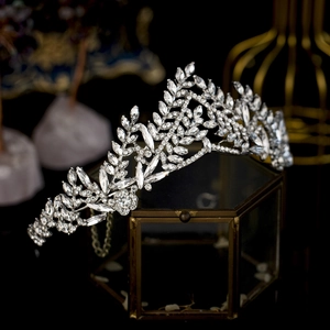 Elegant silver bridal crown with crystal leaf and floral design on a glass jewelry box