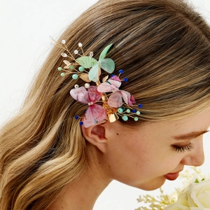 Detail of butterfly hair clip with colorful translucent wings and gold wire beads