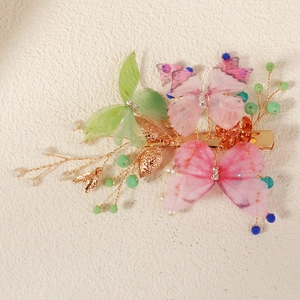 Close-up of butterfly hair clip with translucent fabric wings and crystal beads