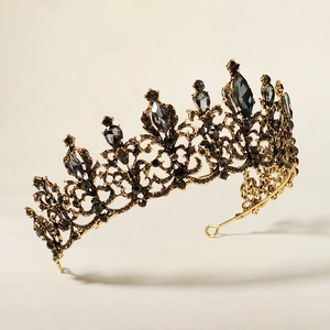 Macro view of vintage gold alloy crown featuring intricate hollow floral patterns and black crystals