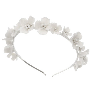 Close-up of white fabric flowers with pearl centers on an elegant bridal headband