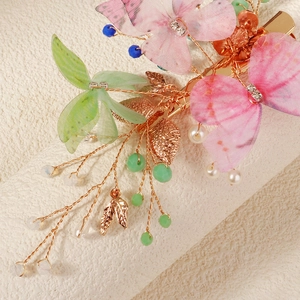 Detailed macro view of butterfly hair clip with pastel tulle petals and pearls