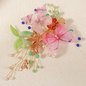 Detail of butterfly hair clip with pink mesh wings, crystals and beaded gold leaves