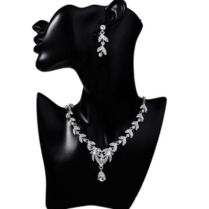 Detail of luxury silver bridal jewelry set with pear-shaped rhinestones on a mannequin