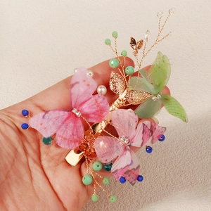 Detail of handcrafted butterfly hair clip with colorful crystal beads and pearls