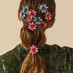 Detail van kleurrijke strass bloem haarspelden gedragen in een paardenstaart