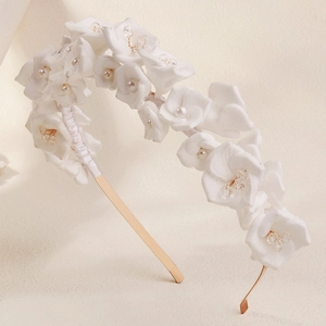 Detailed macro view of white fabric floral petals with delicate pearls and crystals
