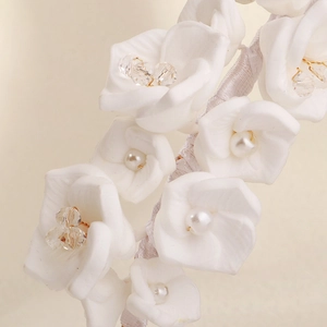 Detailed close-up of handmade white floral bridal headband with pearls and crystals