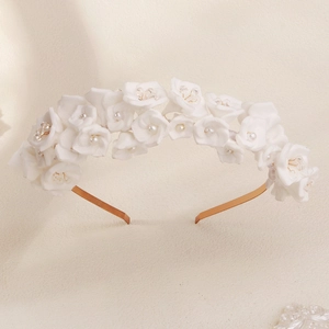 Detail of white floral bridal headband with faux pearls and gold crystals