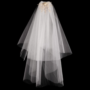 Détail du voile de mariée avec peigne à cheveux doré et élégantes décorations de perles