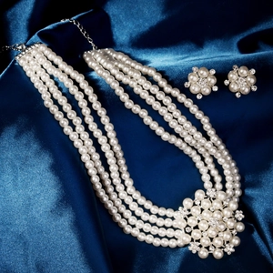 Dettaglio della collana da sposa a quattro strati di perle e orecchini a fiore abbinati