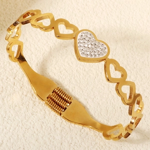 Dettaglio del bracciale dorato a cuori traforati con strass brillanti e chiusura a cerniera