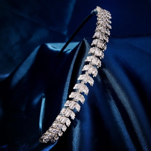Détail d'un serre-tête en zircon de luxe avec cristaux baguette sur fond de soie bleue