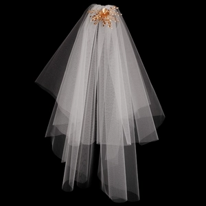 Gros plan du voile de mariée blanc avec peigne à fleurs dorées et détails perlés