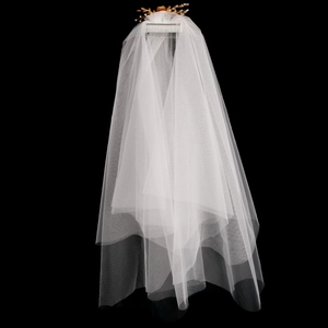 Détail d'un voile de mariée blanc en tulle multicouche avec peigne et feuilles dorées