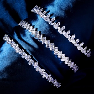 Three elegant zircon bracelets on dark blue silk background with luxury marquise and round cuts