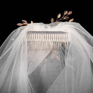 Détail du peigne à voile de mariée avec feuilles d'or rose et cristaux brillants