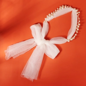 Détail de peigne à cheveux de mariée avec perles élégantes et nœud délicat en tulle blanc