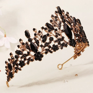 Close-up of vintage black crystal crown with intricate golden floral metal patterns