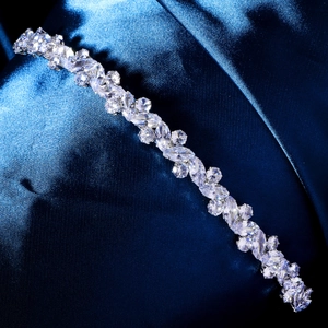 Macro detail of marquise and round cut zircons on a silver headband with claw setting