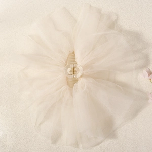 Détail d'un voile de cheveux en résille blanc cassé avec pince acrylique et fleurs roses