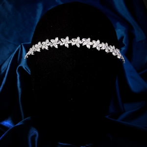 Détail d'un serre-tête fleuri argenté orné de zircons sur fond en satin bleu profond