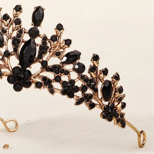 Detailed close-up of gothic vintage gold crown with black gemstones and floral filigree